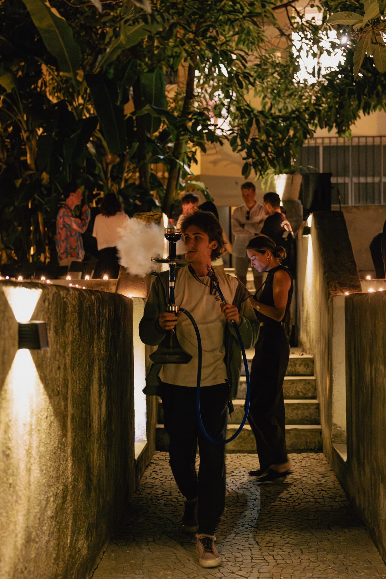 Guest walking through the candlelit garden path