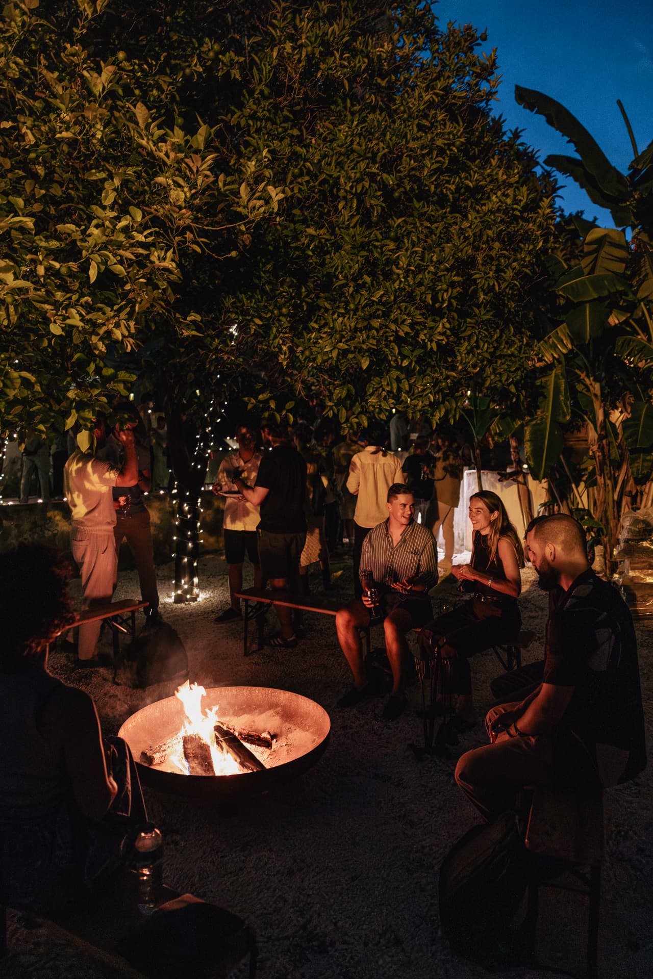 Guests gathered around the fire pit at dusk